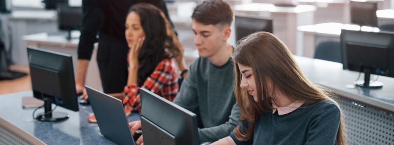 Jóvenes usando las computadoras preparándose con una educación disruptiva